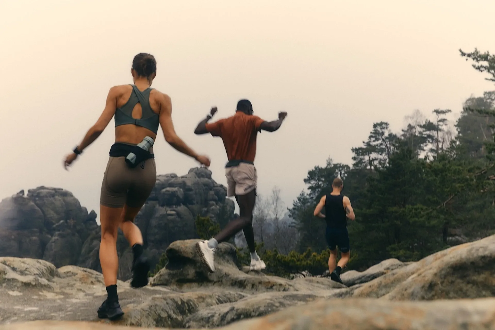 A group of people jogging over some rocks