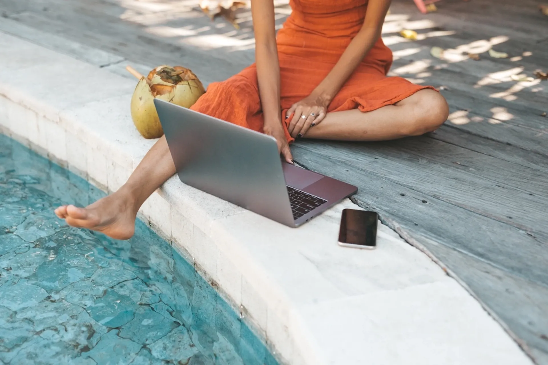 Woman using her laptop by the pool
