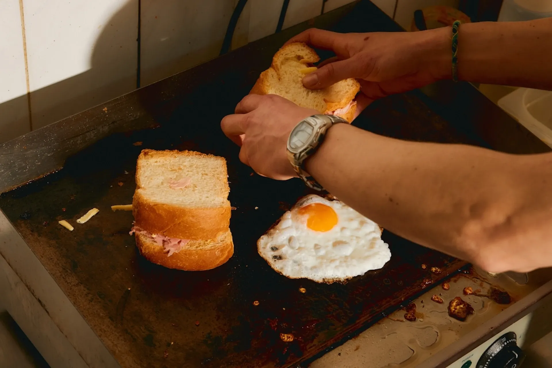 Person making an egg-and-bacon sandwich