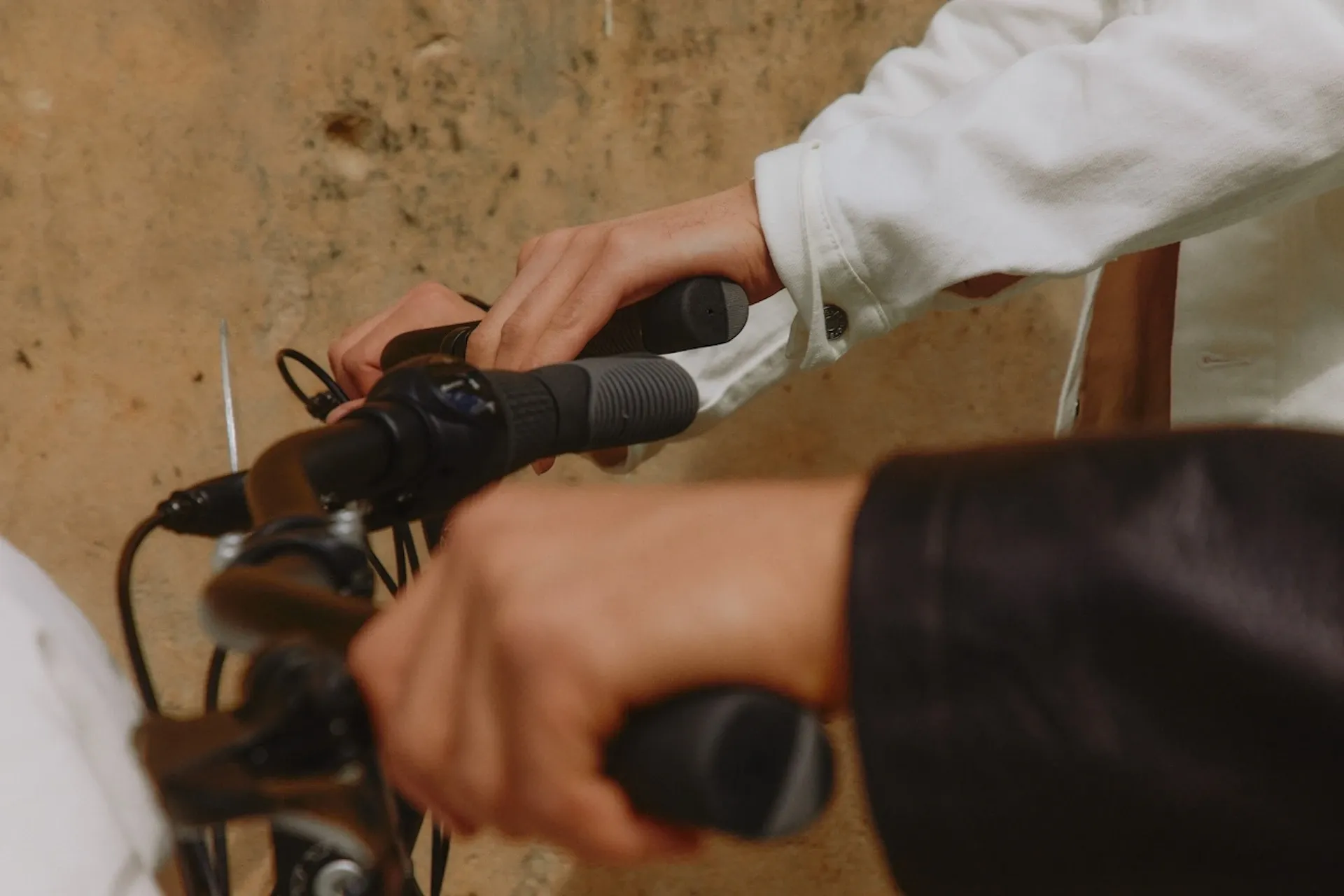 Hands gripping the handlebars of a bike