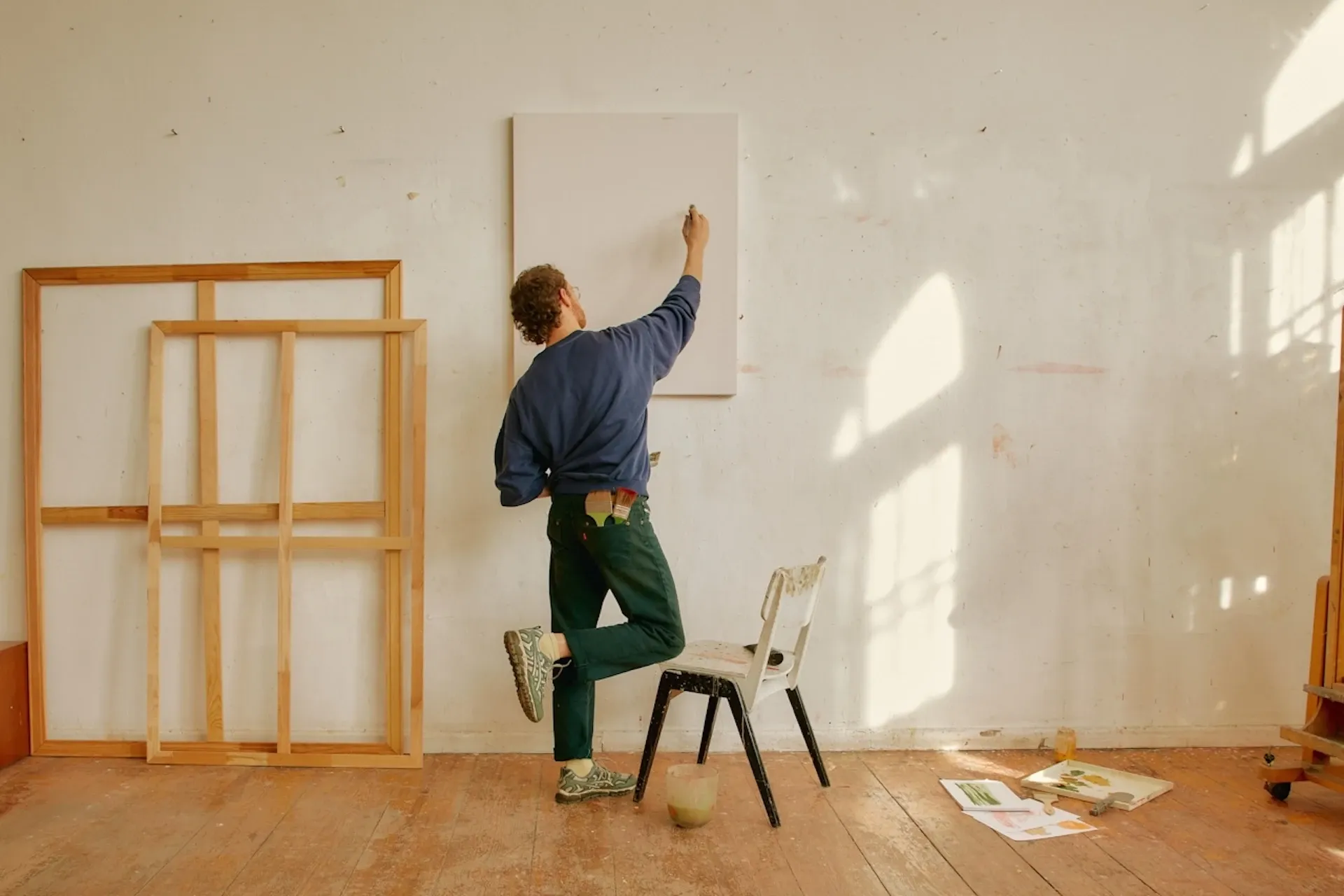 Man painting a canvas on a wall