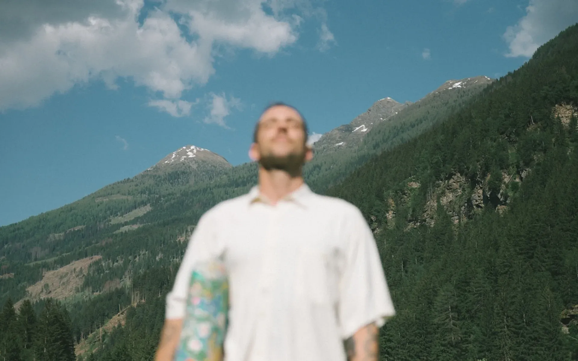 A man looking relaxed in a mountain range