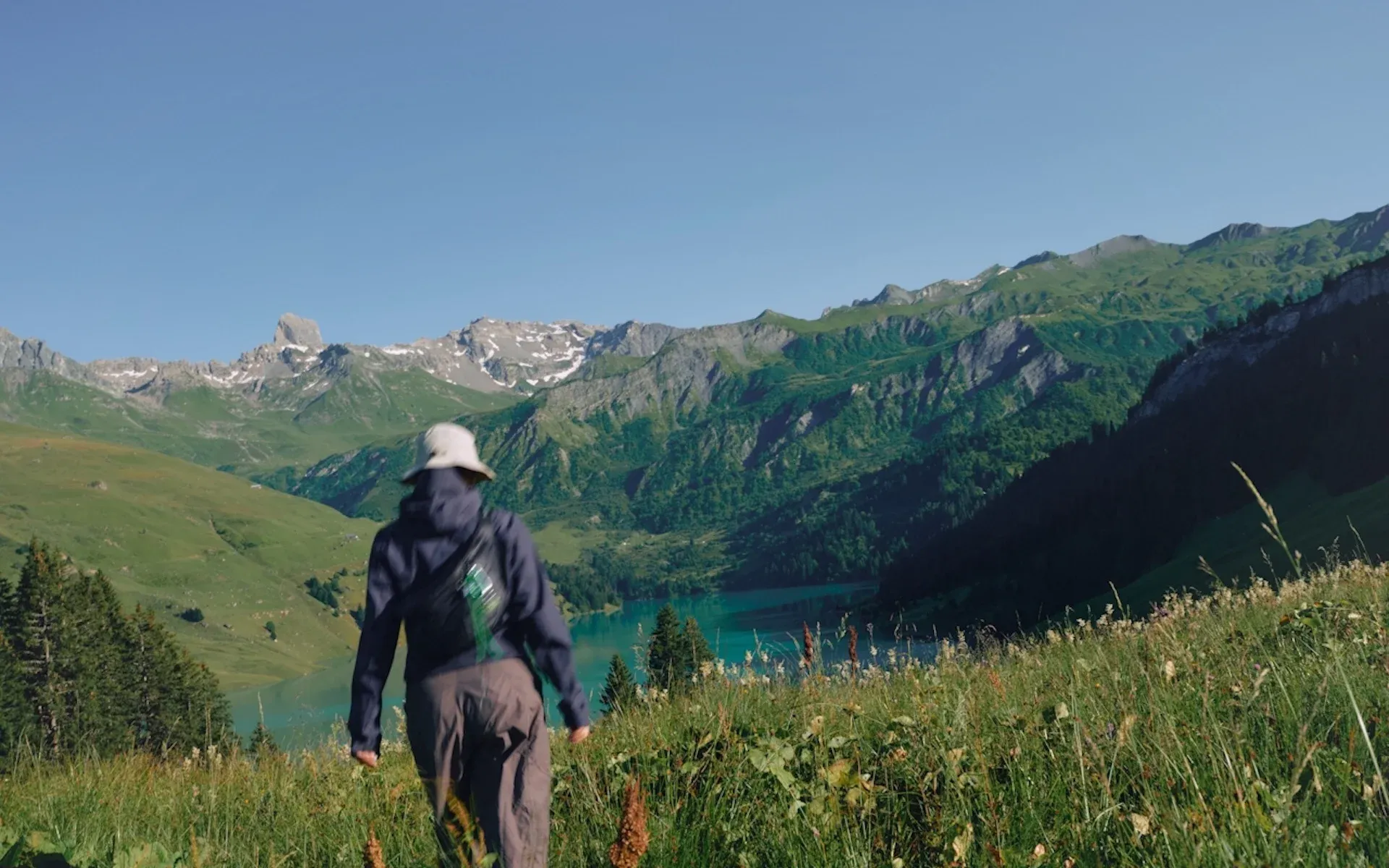 A person hiking in the mountains wearing a bucket hat