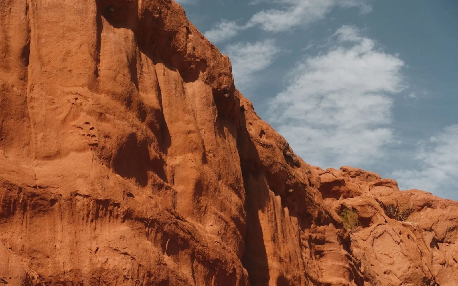A red cliff face with blue sky overhead