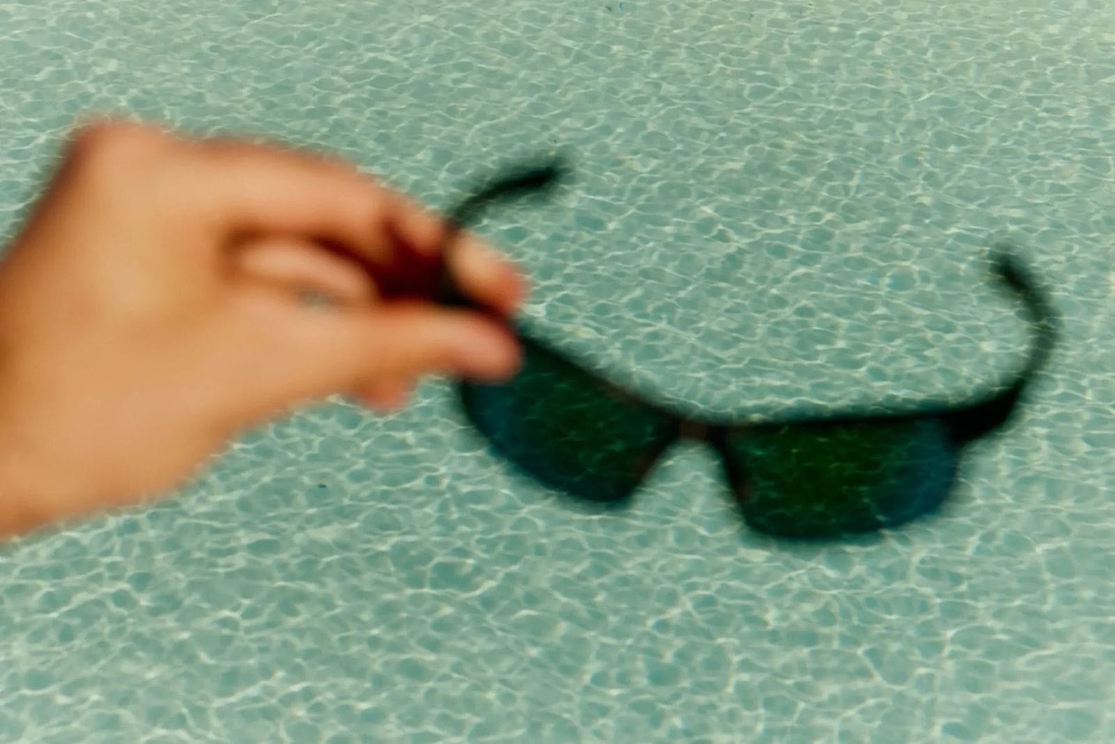 Sunglasses in front of a swimming pool