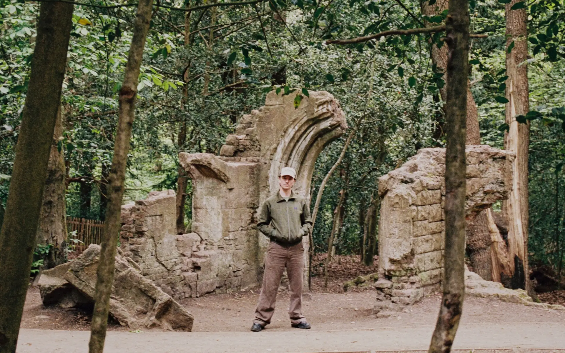 Ross From Friends standing in front of an old ruin.