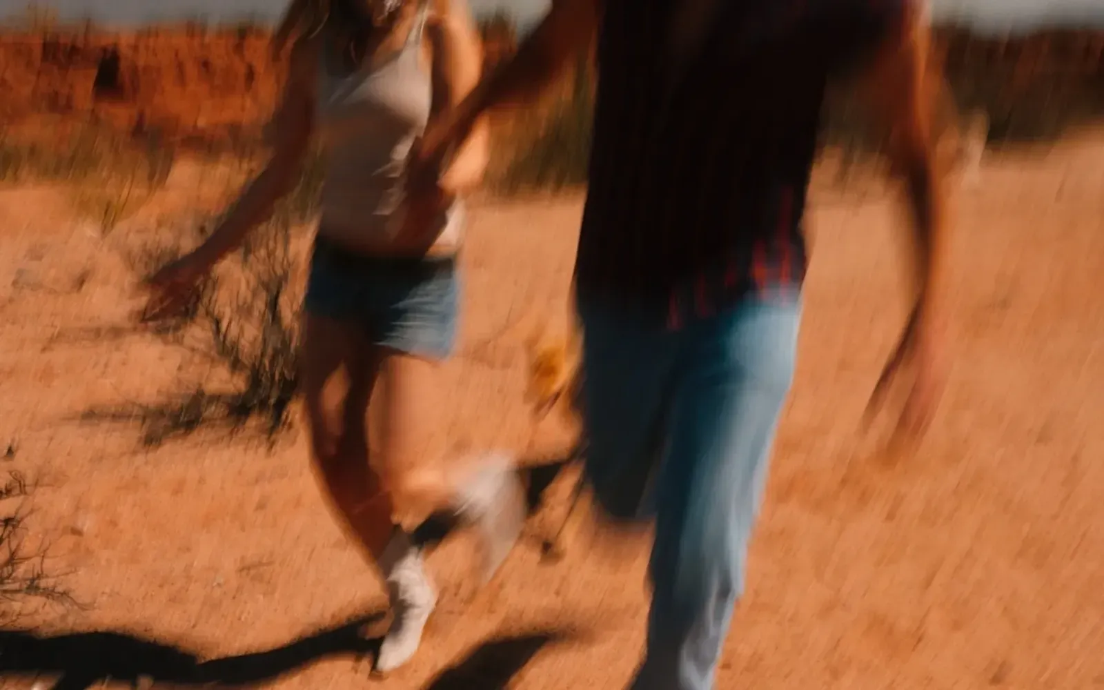 Two people running through the desert