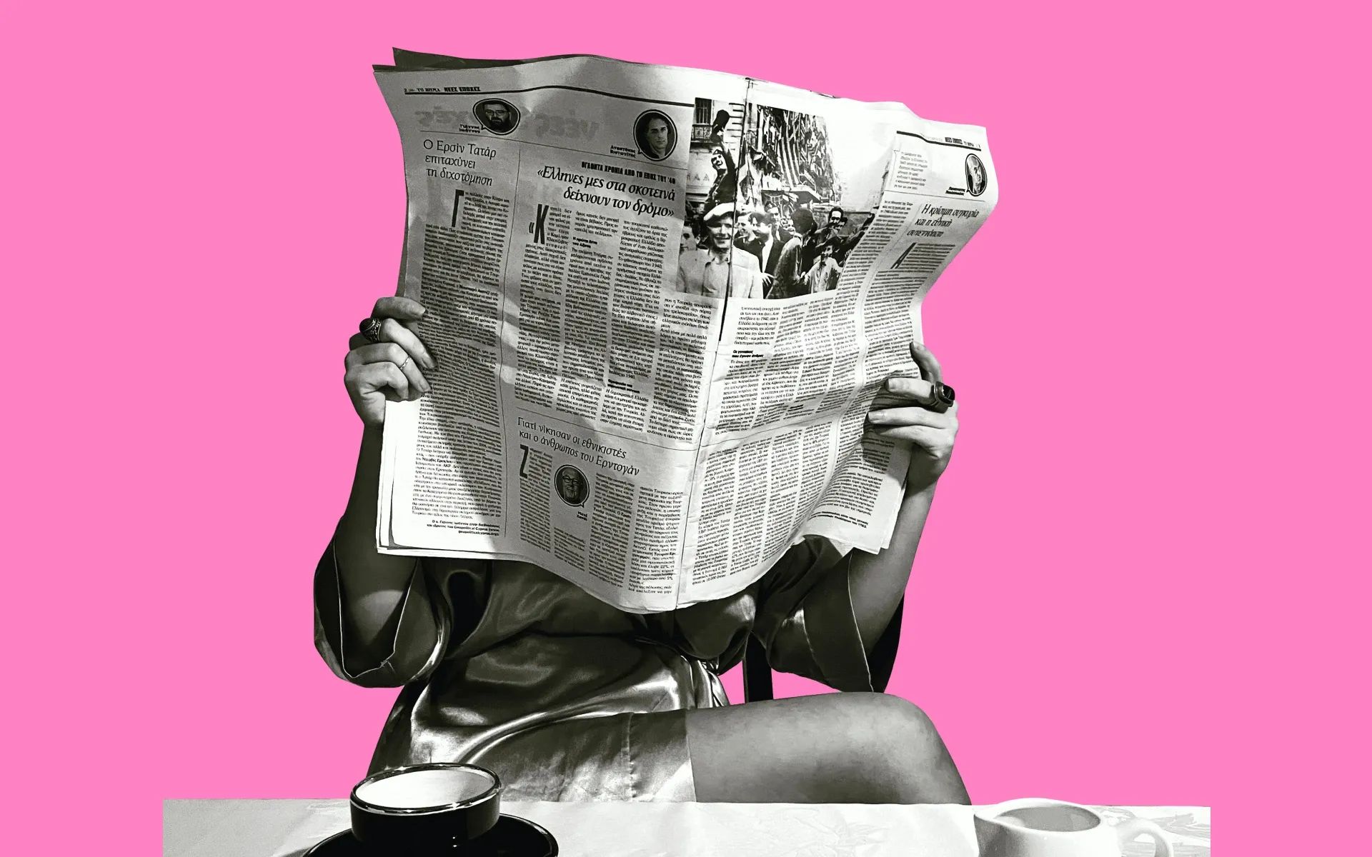 A person reading the newspaper in front of a coffee table