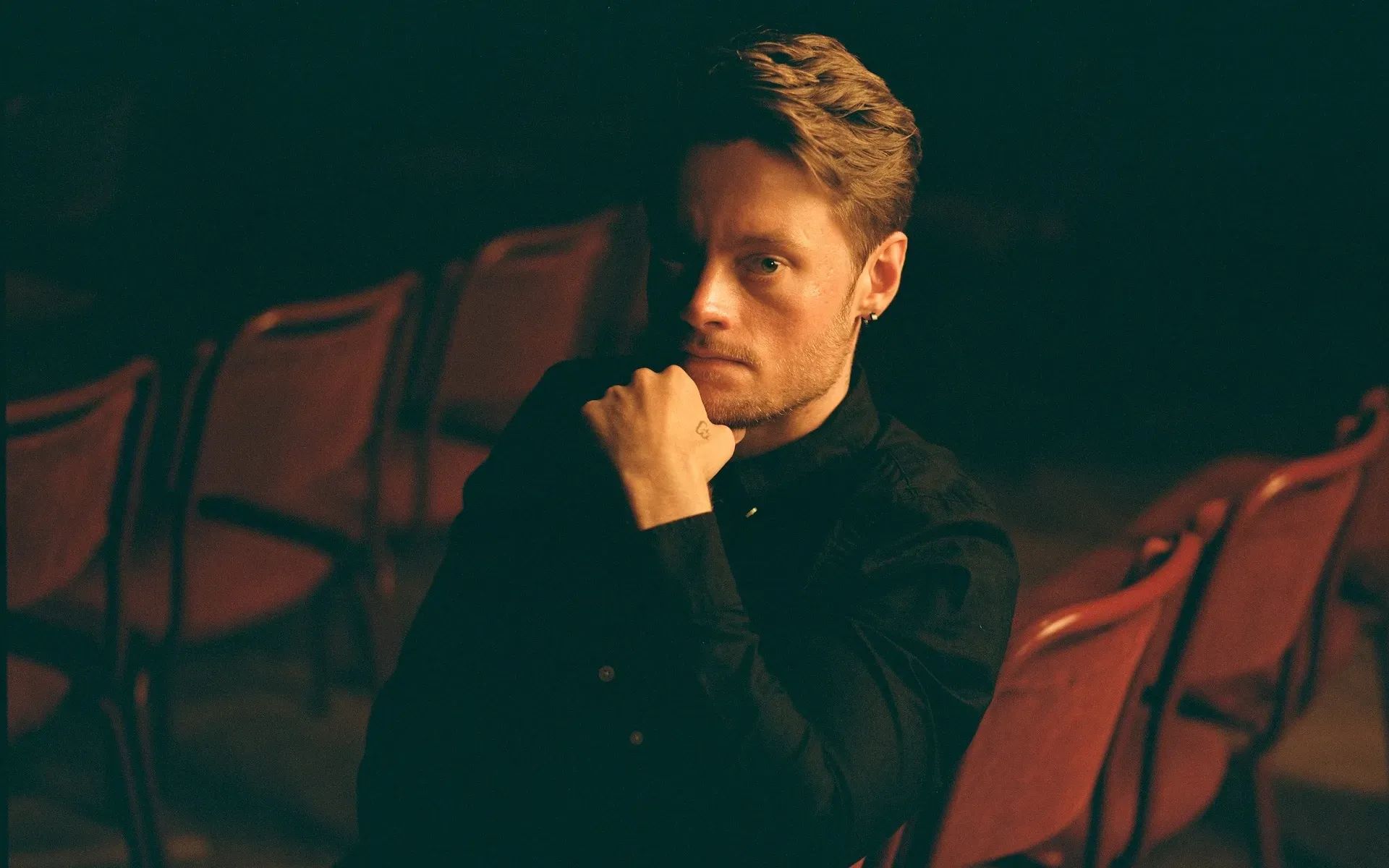 A photo of Christoffer Moe Ditlevsen, sitting on a red chair. Photo by Sune Chee.