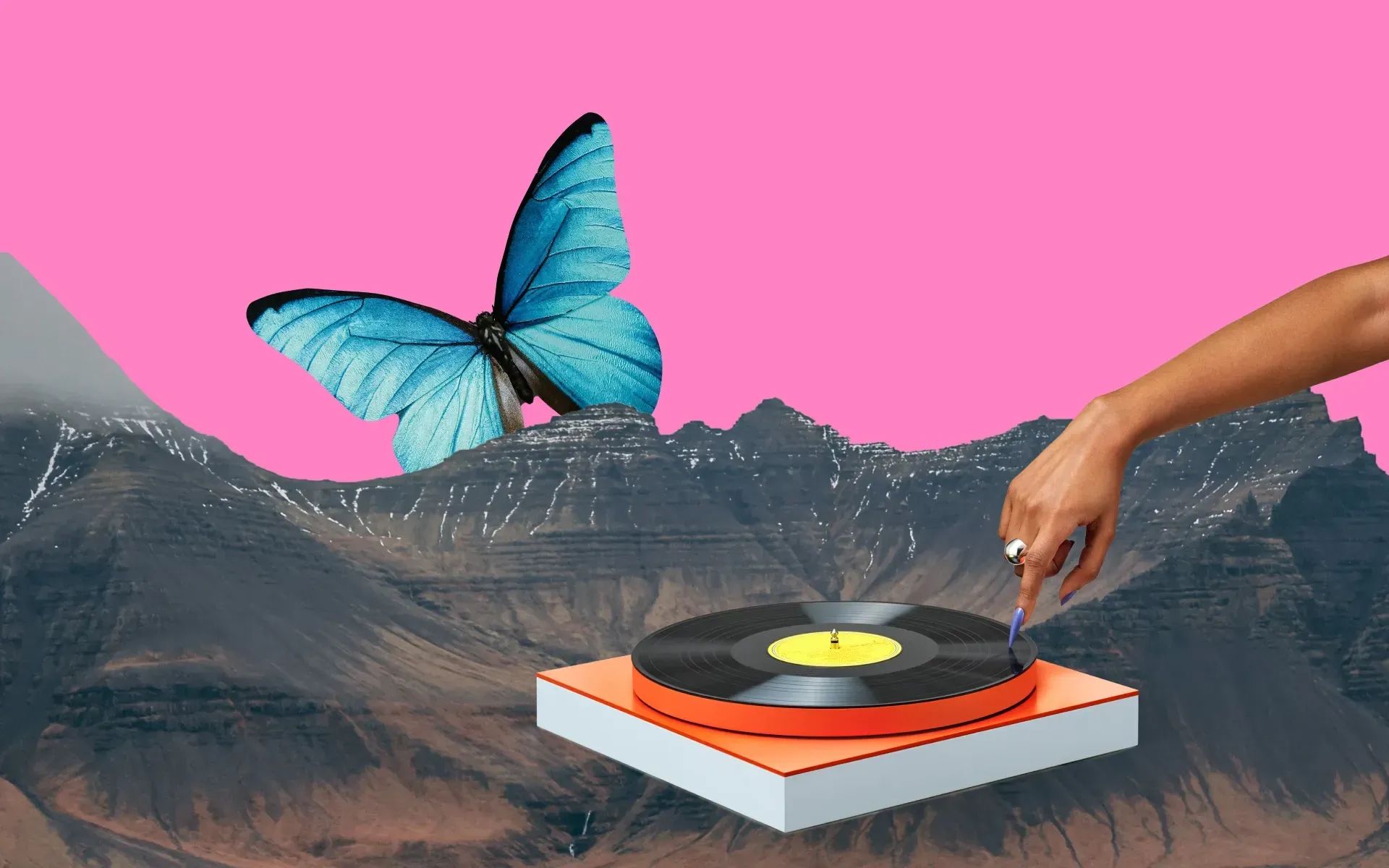 A hand touching a turntable, which is floating in the mountains next to a giant butterfly