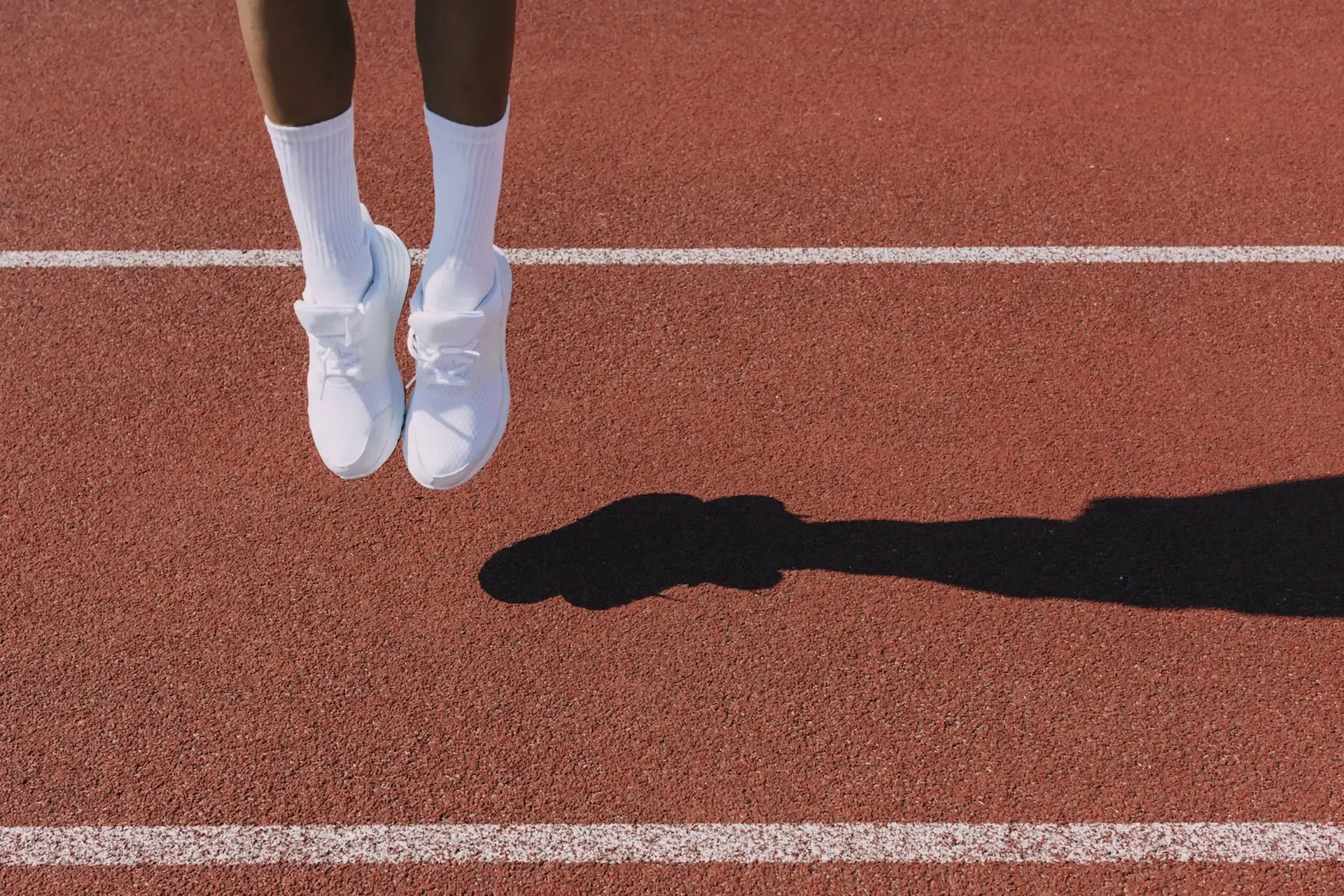 A person’s legs jumping from a racetrack