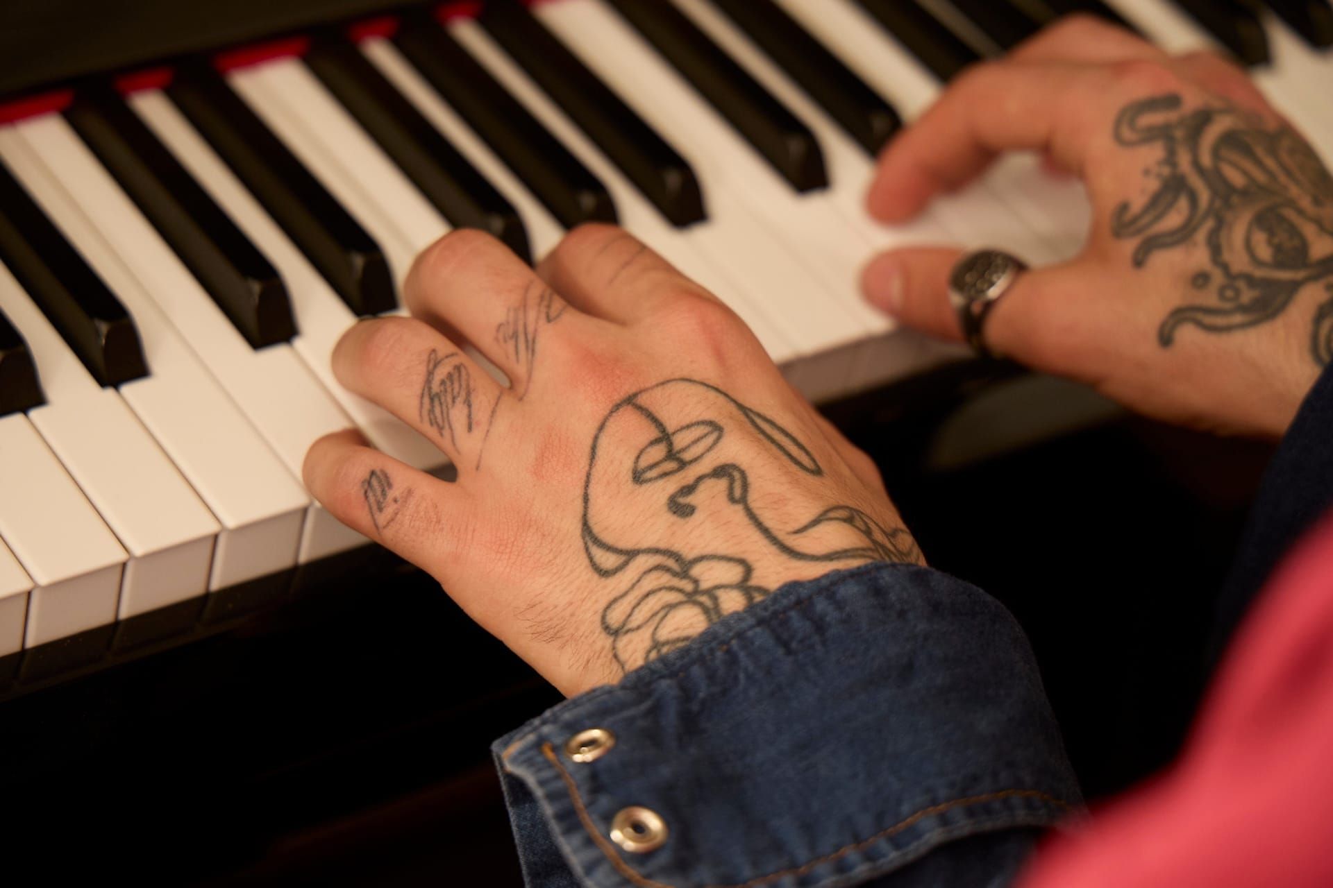 Tattooed hands playing piano