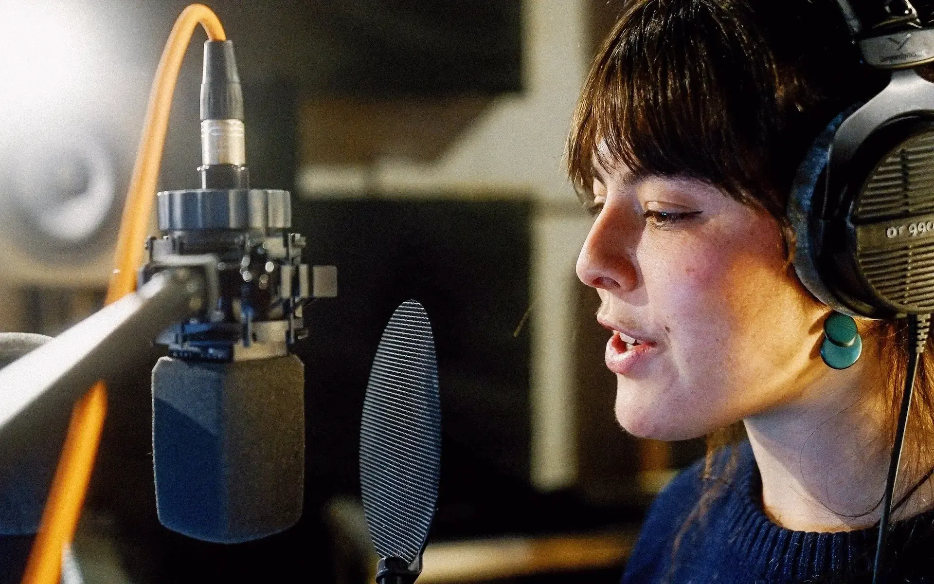 A voiceover artist recording in a booth