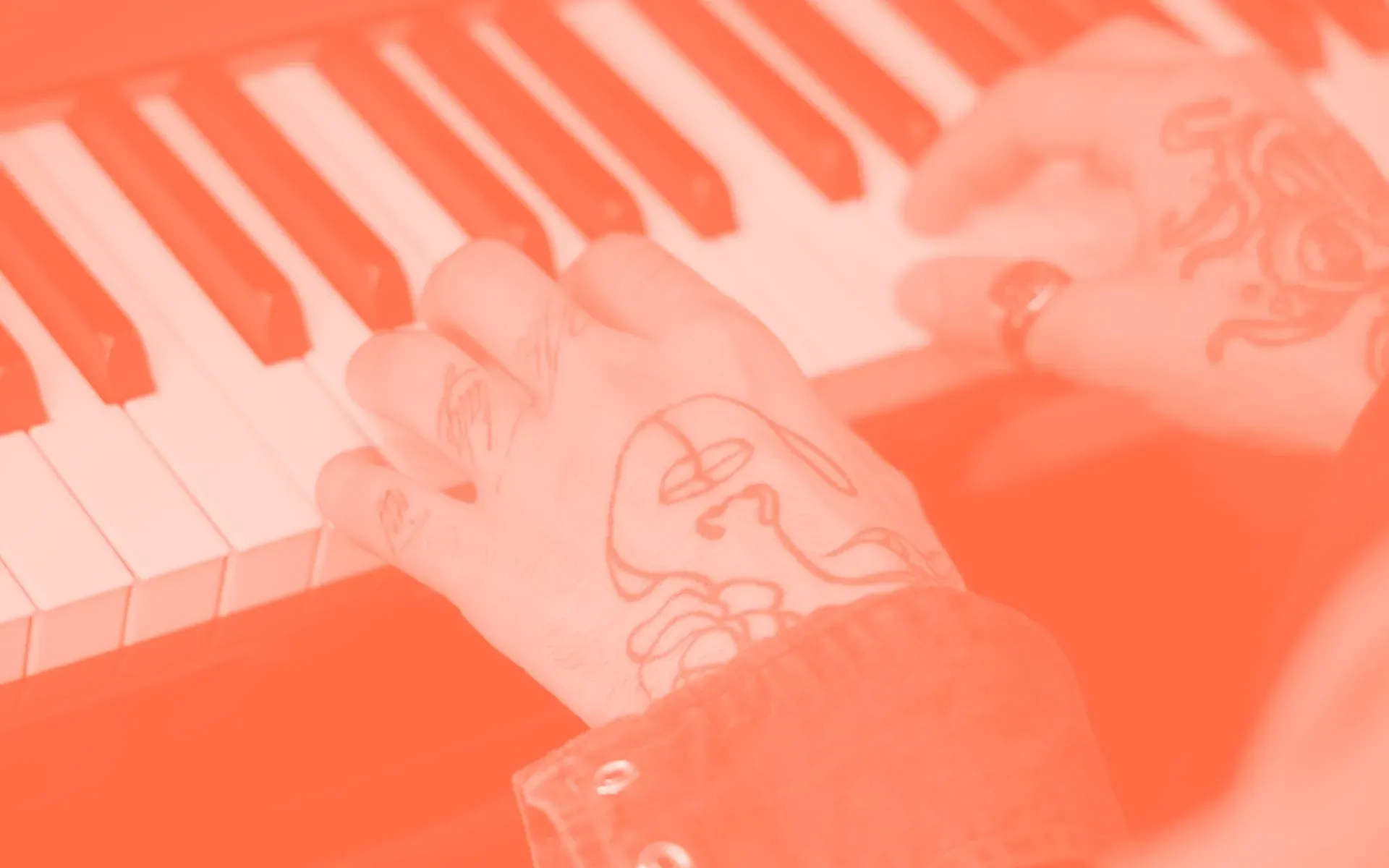 Tattooed hands playing piano