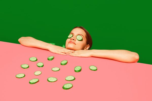 Woman with cucumber slices over her eyes 