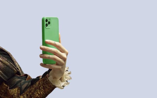 Person’s arm, dressed in old-fashioned clothes, taking a selfie