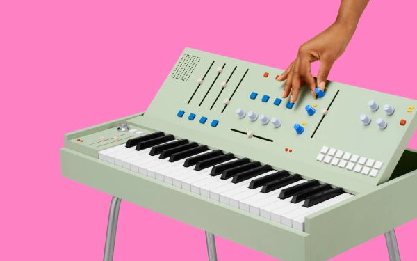 A hand reaching down to adjust a knob on an abstract-looking keyboard instrument