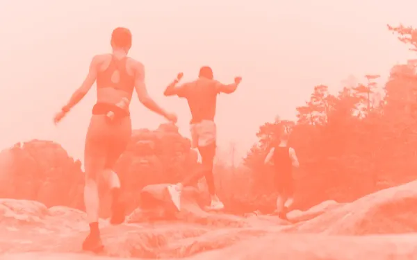 Three people running on some stones