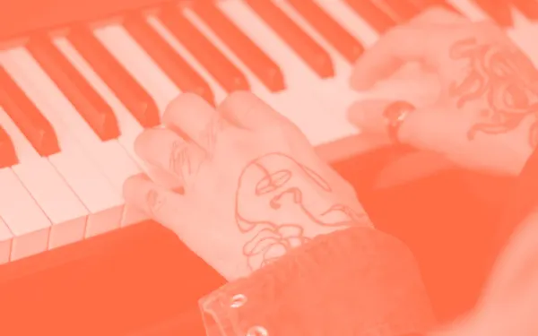 Tattooed hands playing piano