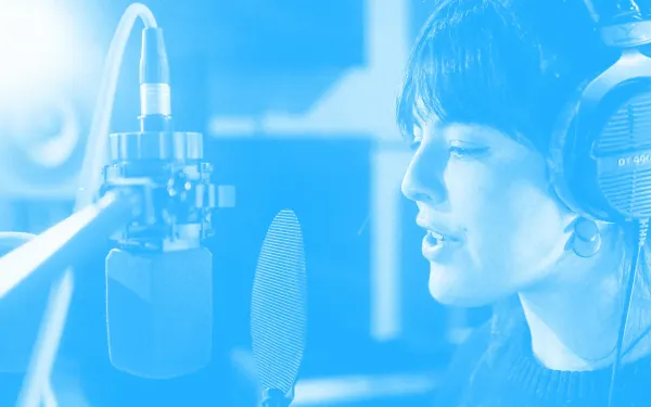 A voiceover artist recording in a booth