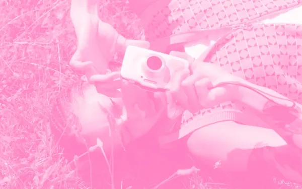 Woman sitting in the grass with a camera