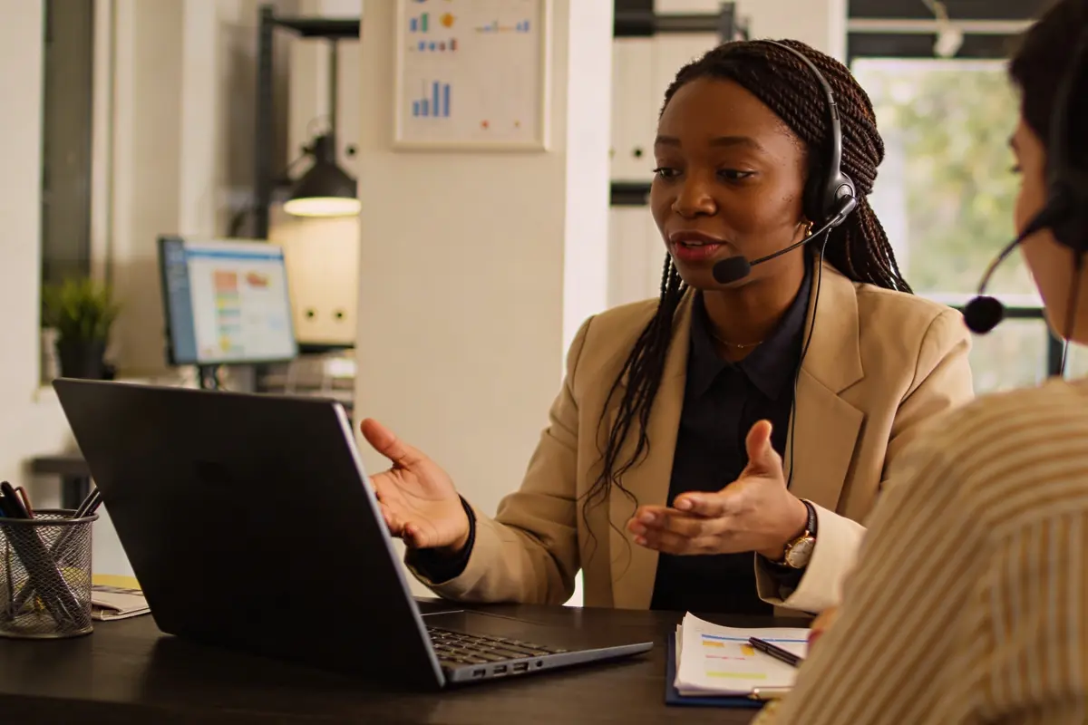 Customer support specialist discussing escalated cases with a colleague in a modern office