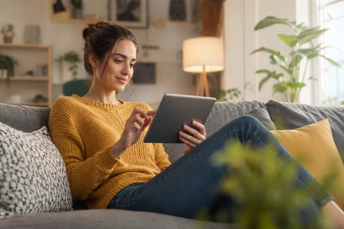 A customer relaxing at home using a tablet to get quick help while browsing, with no visible text or logos