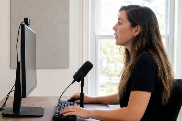 Online course creator recording a lesson with a webcam and microphone at her computer