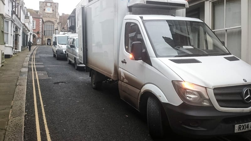 Three delivery lorries parked in a row outside The George's side entrance.