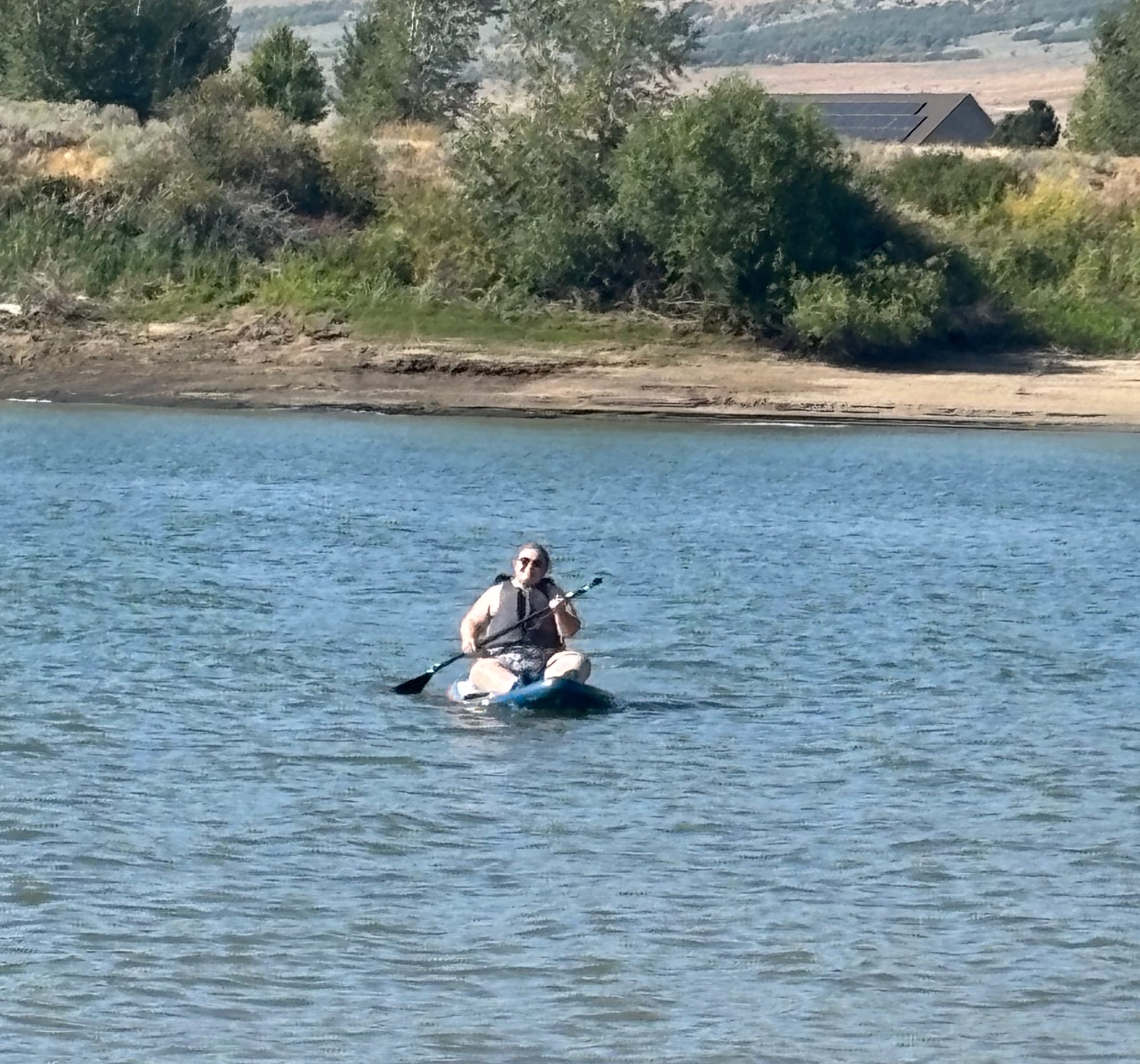 My wife Shannon paddle boarding on the lake with a large smile on her face