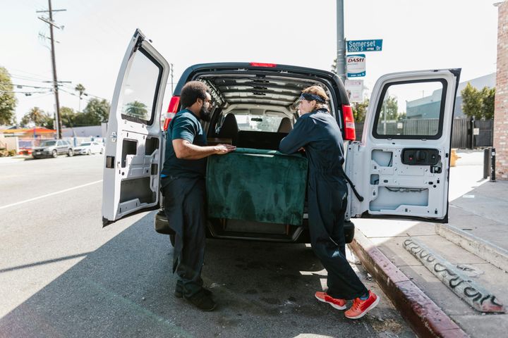 Two men loading furniture into a van