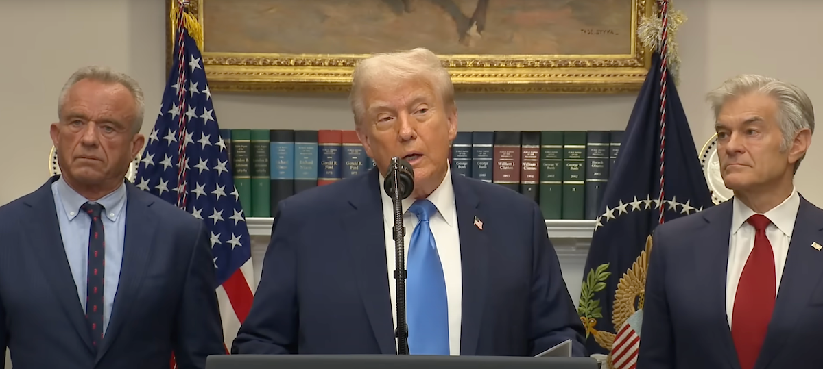 Donald Trump speaks at a podium flanked by RFK Jr and Dr. Oz