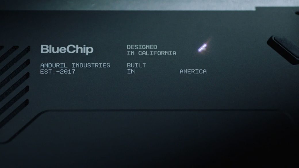 Close-up of the dark casing of Anduril's BlueChip laptop, with vent slots and etched text reading BlueChip, Designed in California, Built in America