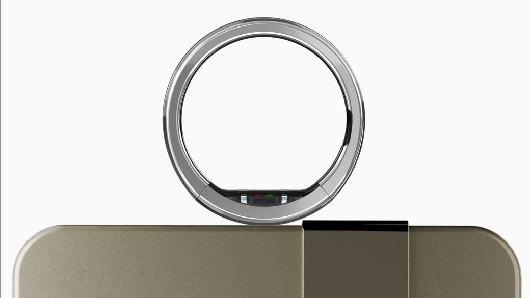 Ultrahuman Ring Pro, a silver titanium smart ring, resting on its gold charging case