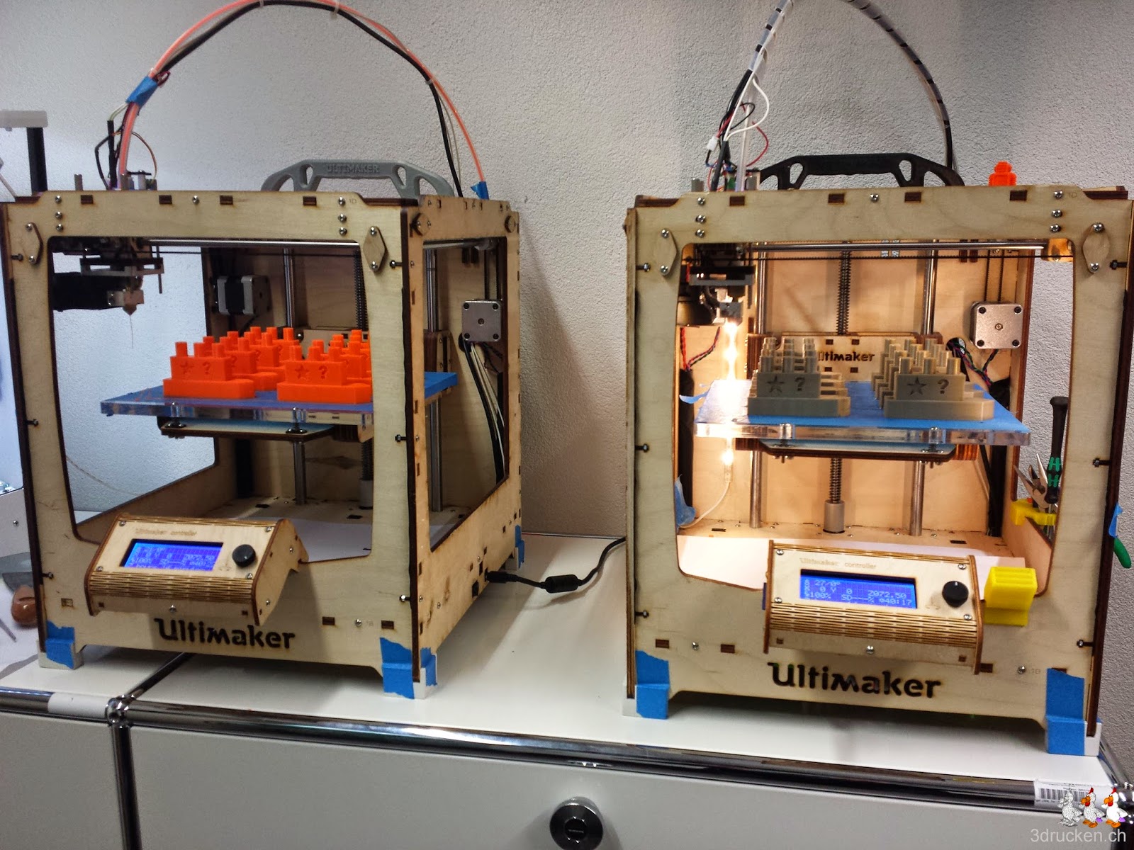 Foto von zwei Ultimaker Original 3D-Drucker mit Drucktischen voller Schiff-Modelle