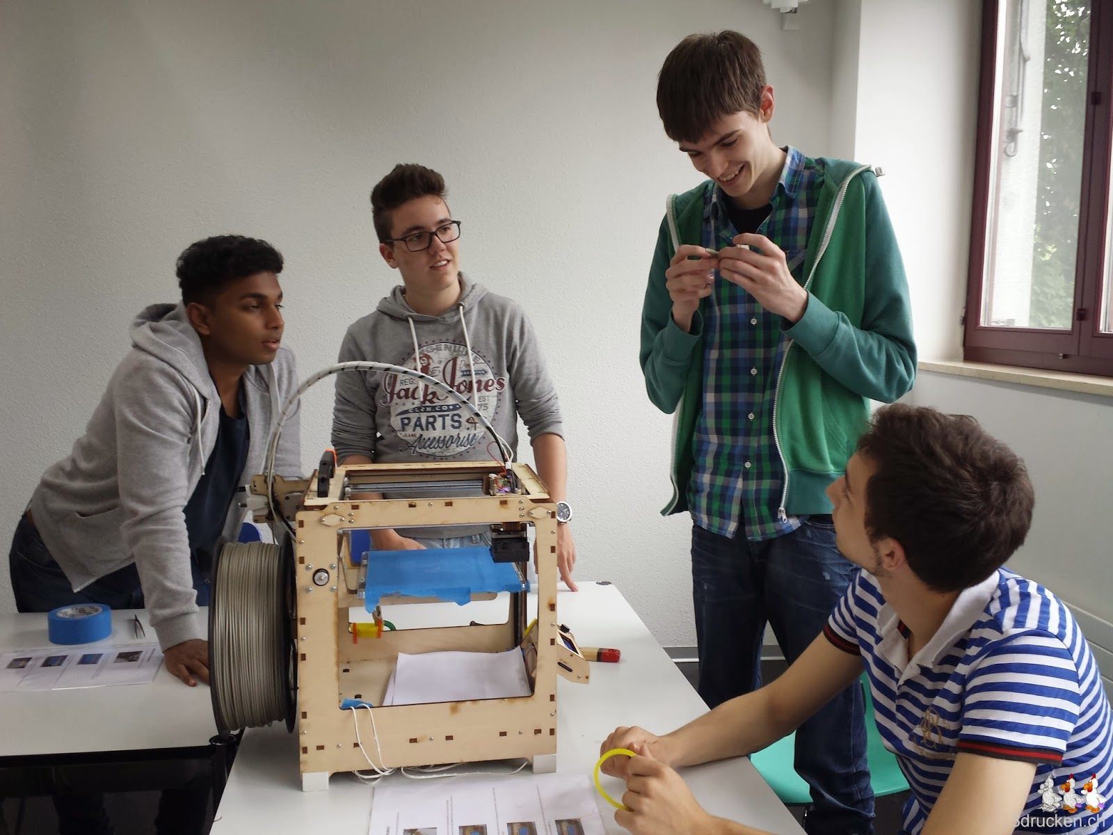 Foto einer Gruppe von Lernenden mit ihrem ersten selber entworfenen und erfolgreich mit dem Ultimaker Original gedruckten Objekt