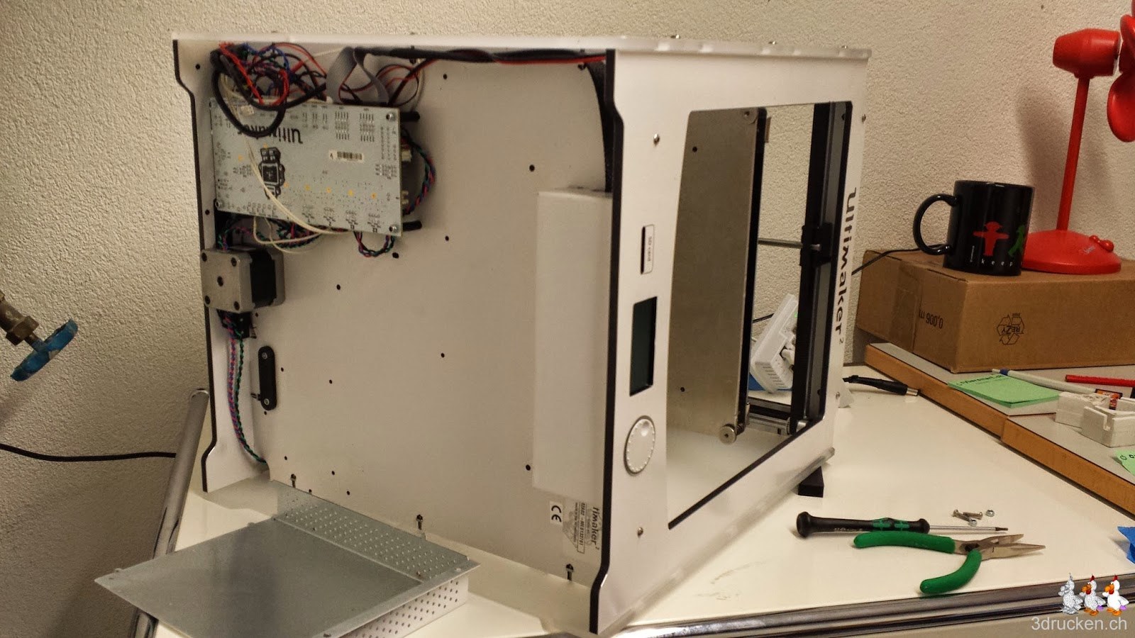 Foto des auf der Seite liegenden Ultimaker 2 mit demontiertem Verdeck der Elektronik