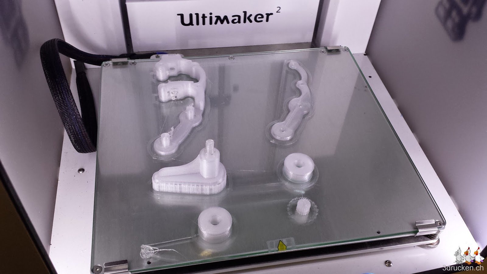 Foto der Einzelteile des Yet Another Ultimaker 2 Feeder aus ColorFabb XT auf dem Drucktisch des Ultimaker 2