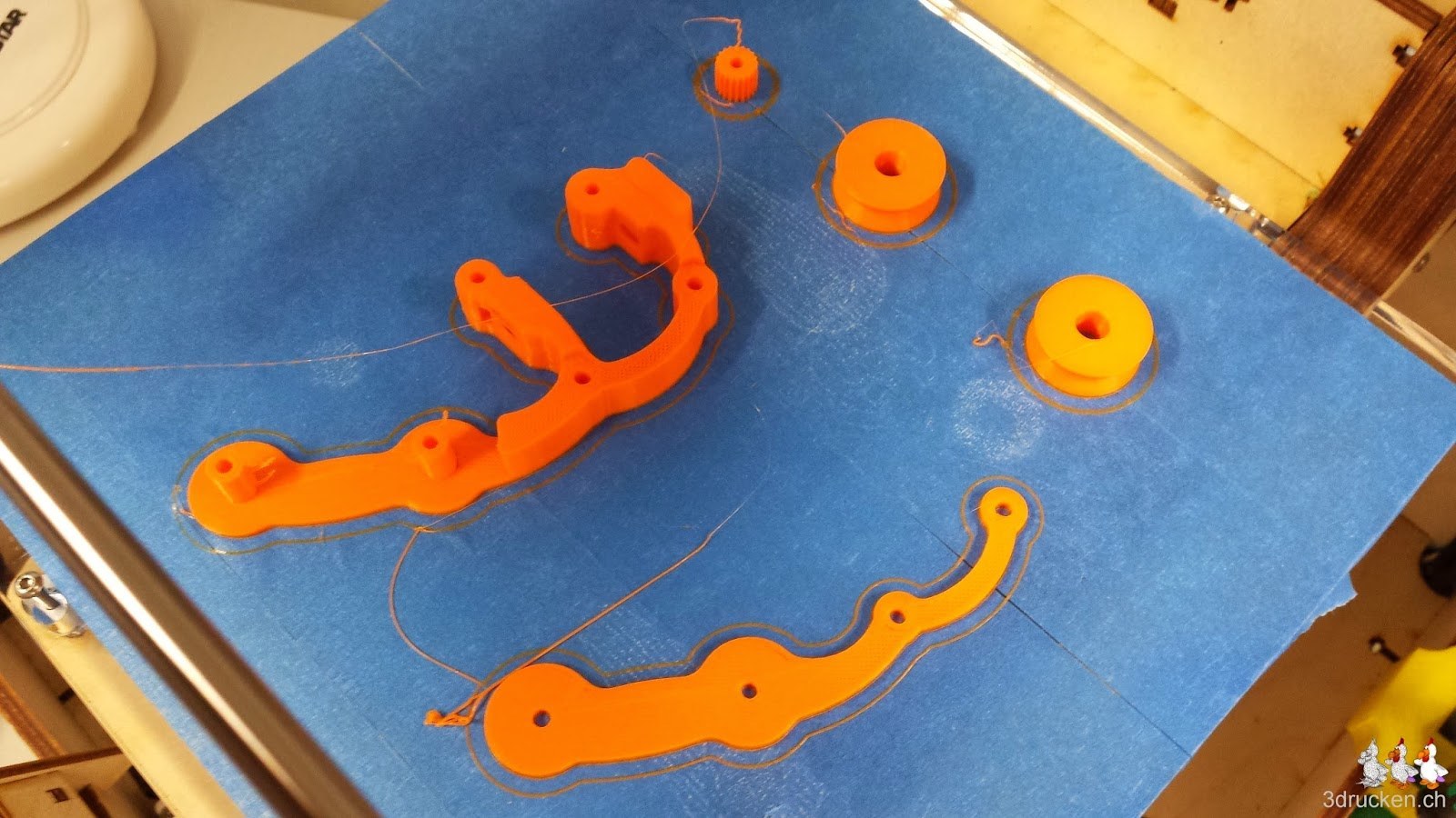 Foto der Einzelteile des Yet Another Ultimaker 2 Feeder aus PLA auf dem Drucktisch des Ultimaker Original