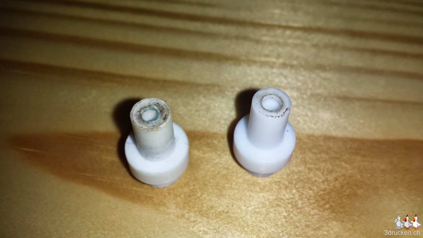 Foto mit zwei Isolatoren, links aus reinem Teflon, rechts versetzt mit Glas