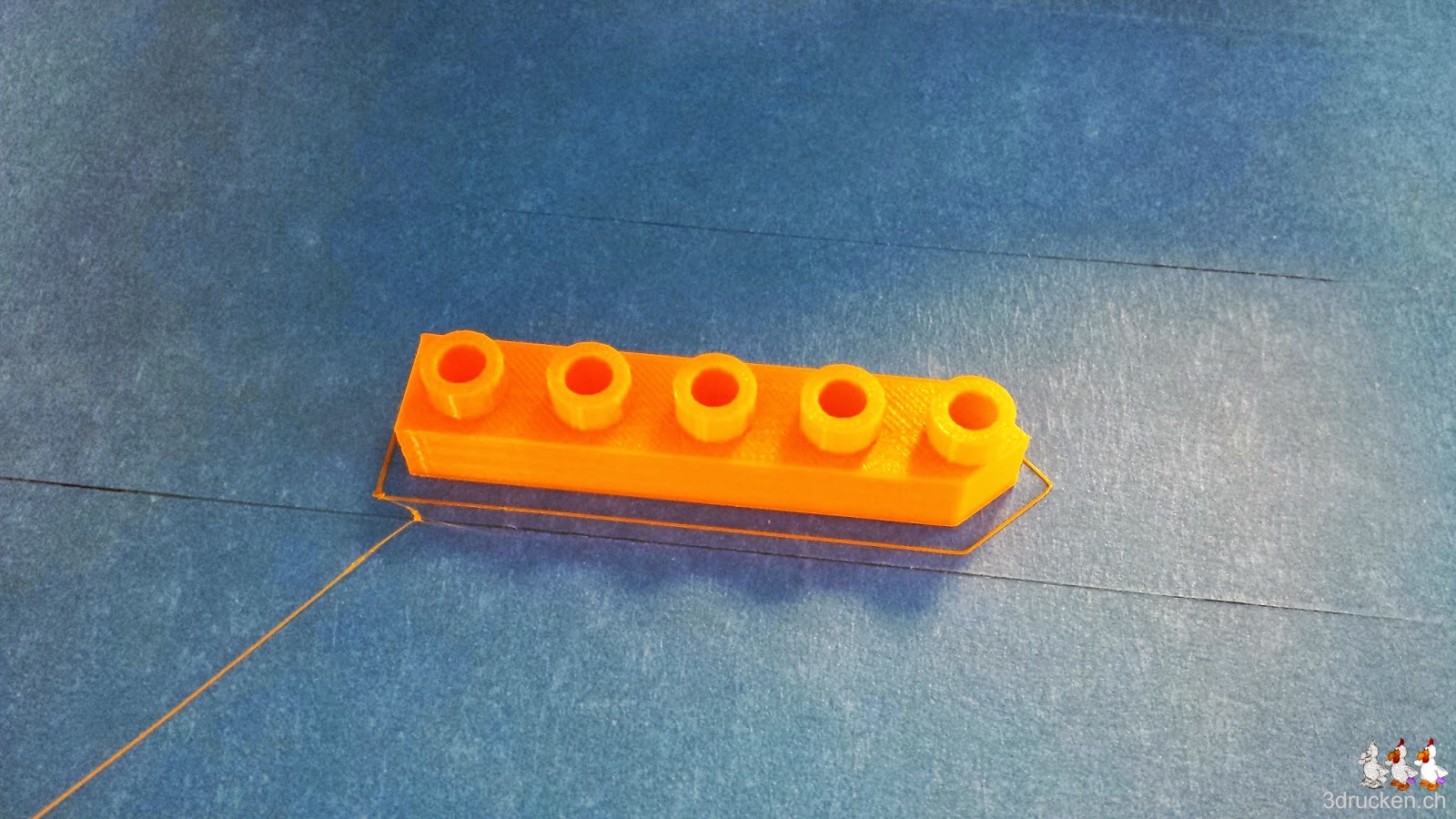 Foto eines 5er-Schiffes aus orangem PLA auf dem Drucktisch eines Ultimaker Original