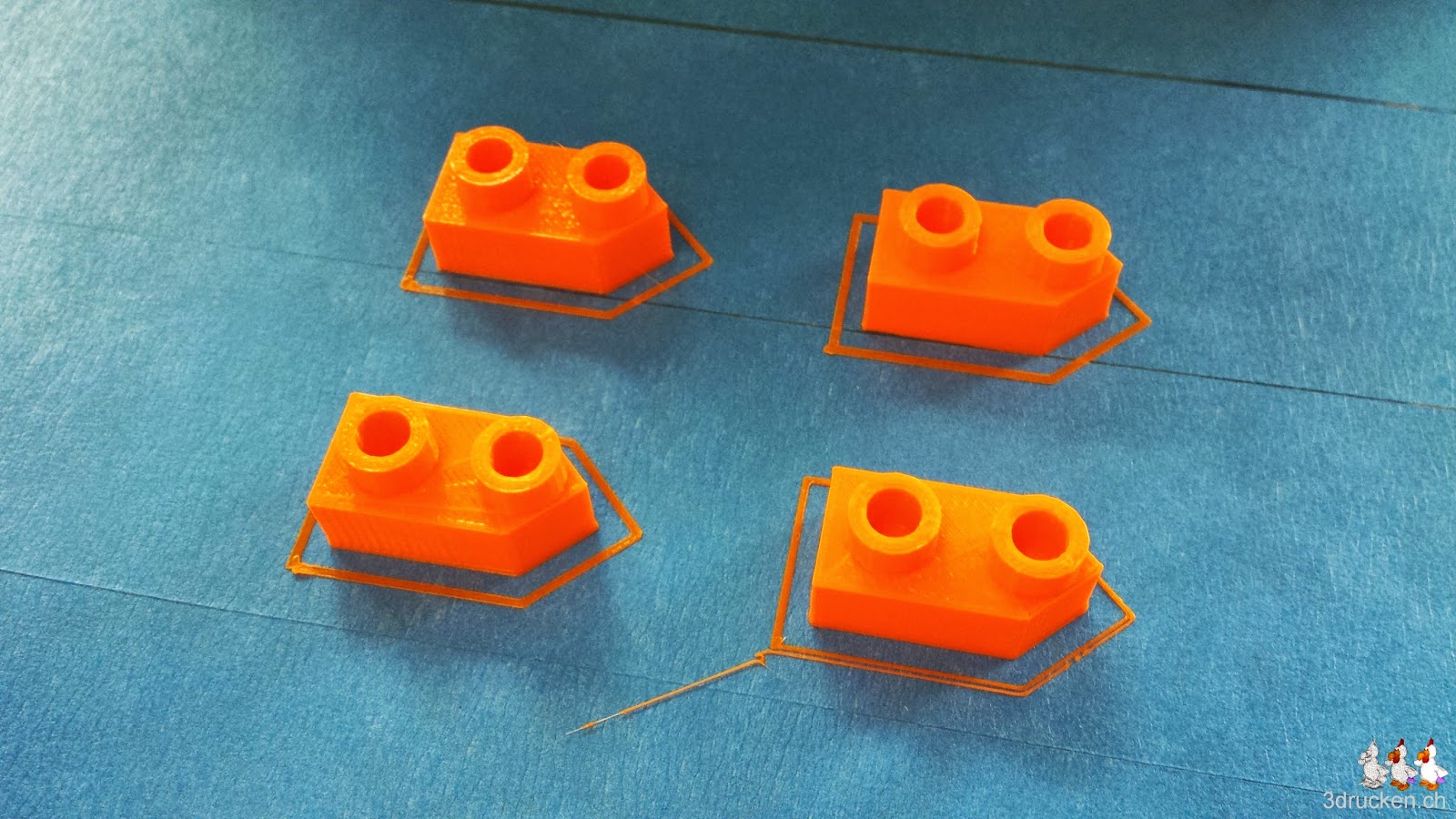 Foto von vier 2er-Schiffen aus orangem PLA auf dem Drucktisch eines Ultimaker Original
