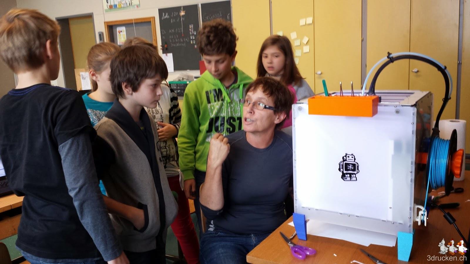 Foto einer Gruppe Schülerinnen und Schüler mit Uorschla am 3D-Drucker Ultimaker 2