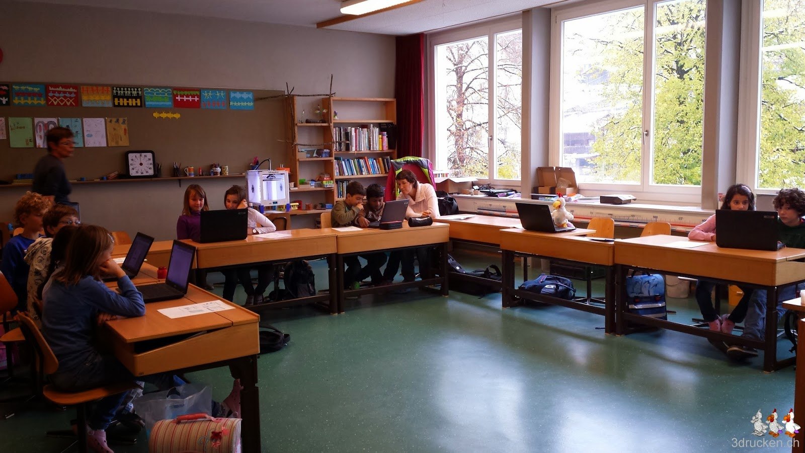 Foto des Klassenzimmers mit fleissig arbeitenden Schülerinnen und Schülern