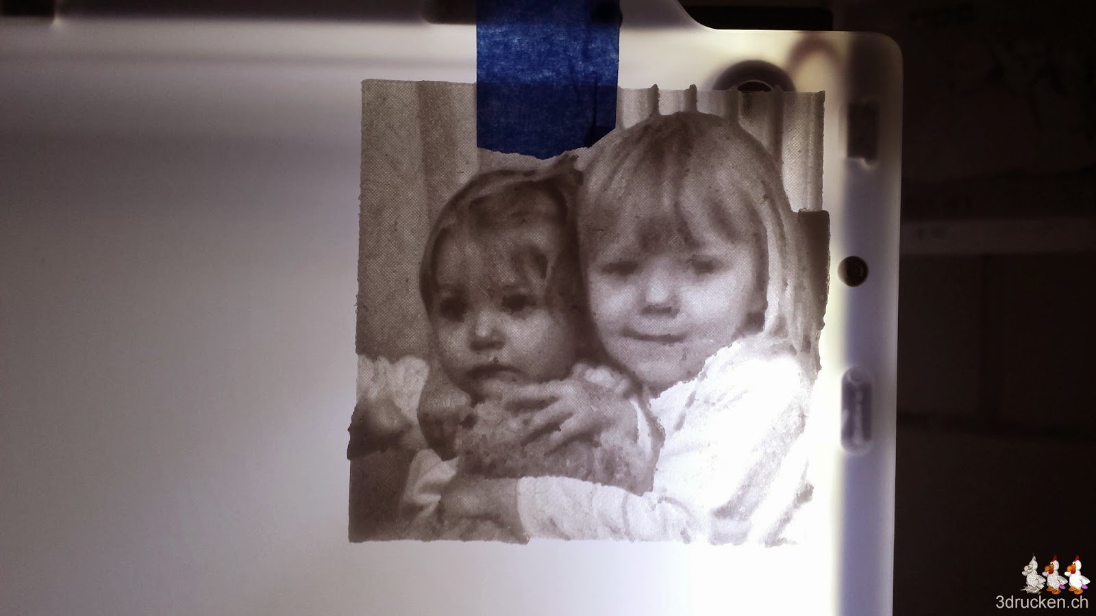 Foto der fertig gedruckten Lithophane mit Hintergrundbeleuchtung der LEDs des Ultimaker 2 am Drucker aufgehängt