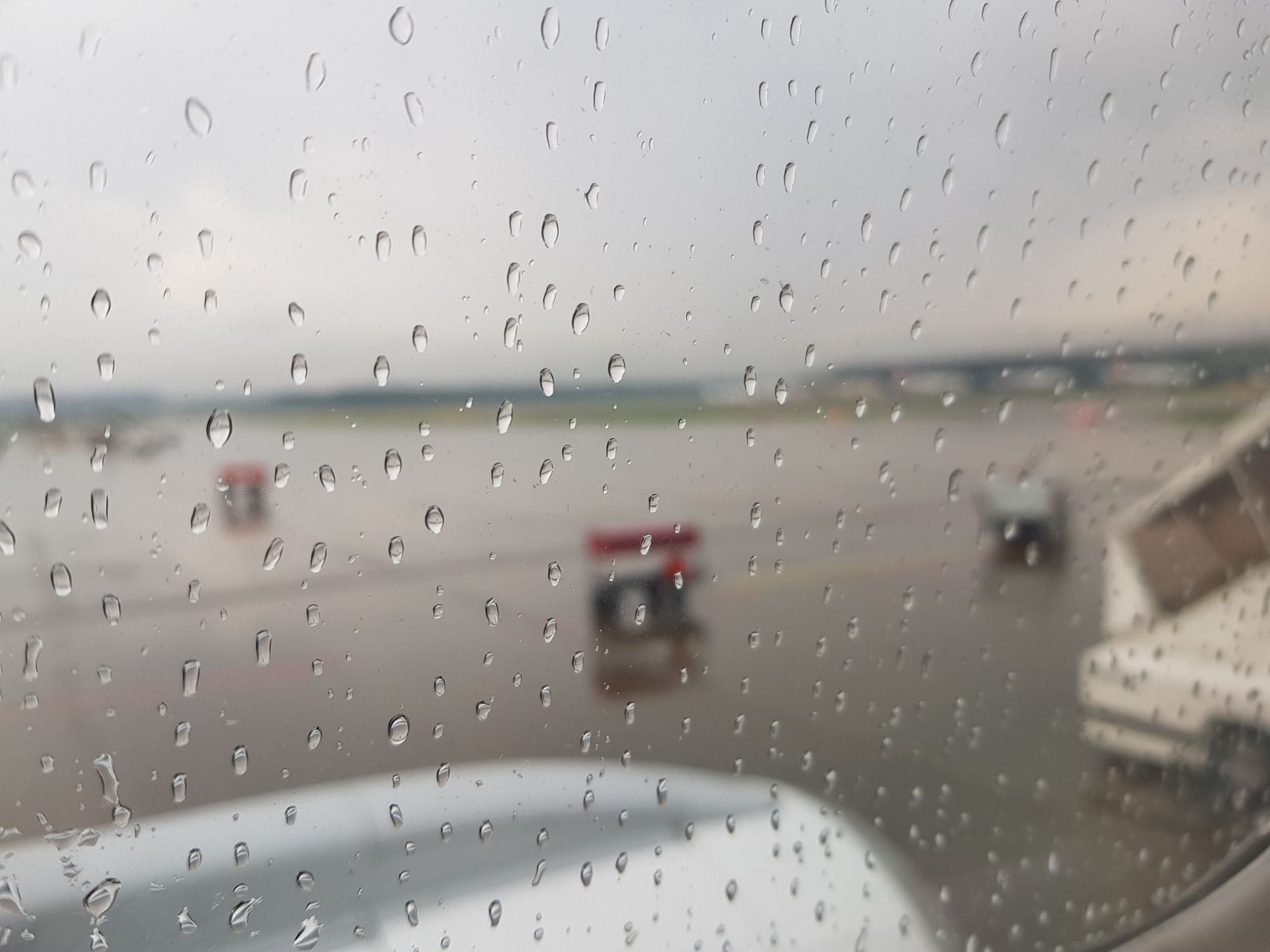 Regentropfen an der Scheibe des Flugzeugs in Zürich. 