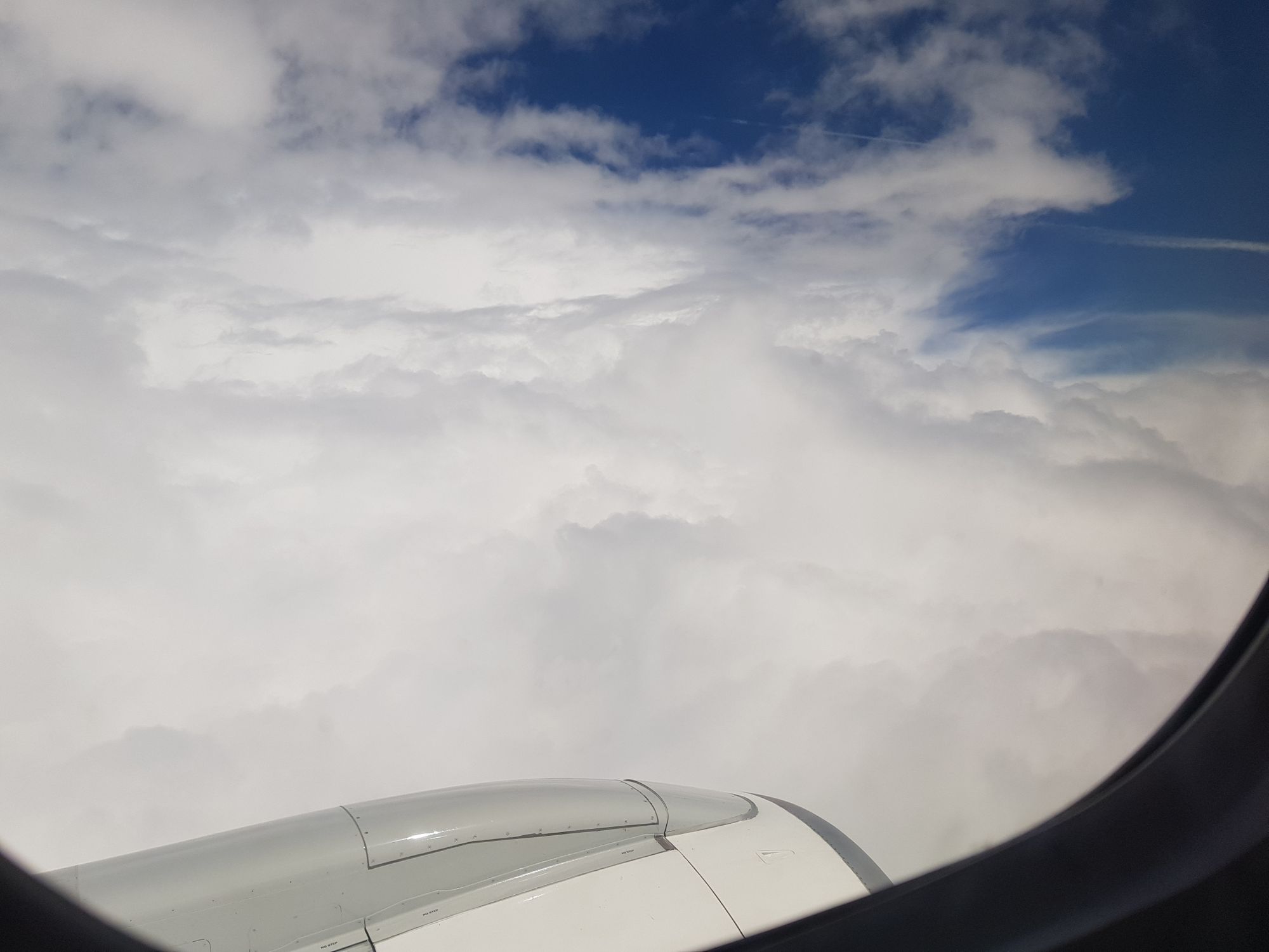 Wolken und das Triebwerk des Flugzeugs aus dem Fenster fotografiert. 