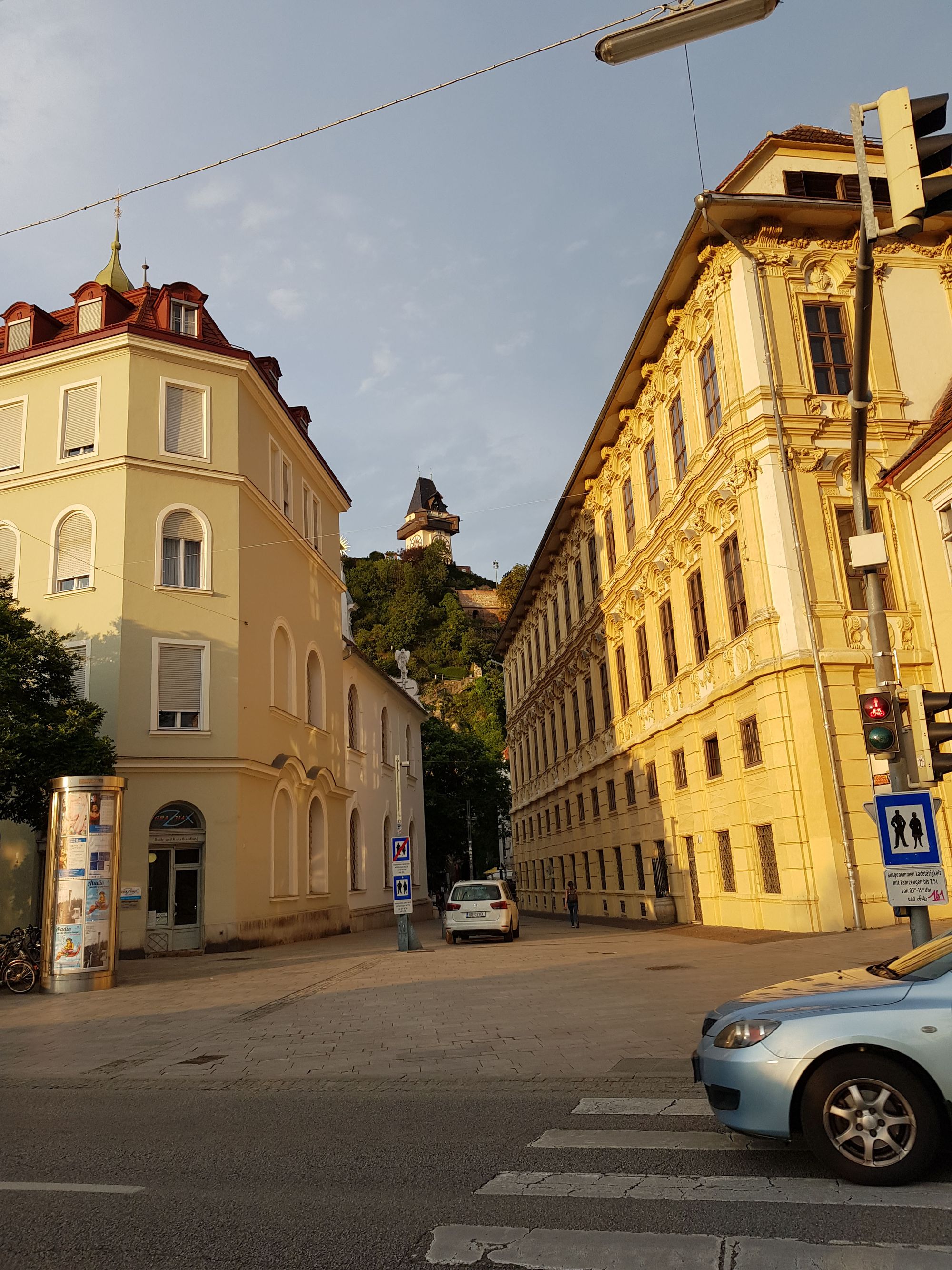 Sicht durch eine Gasse auf den Grazer Uhrturm im Hintergrund.