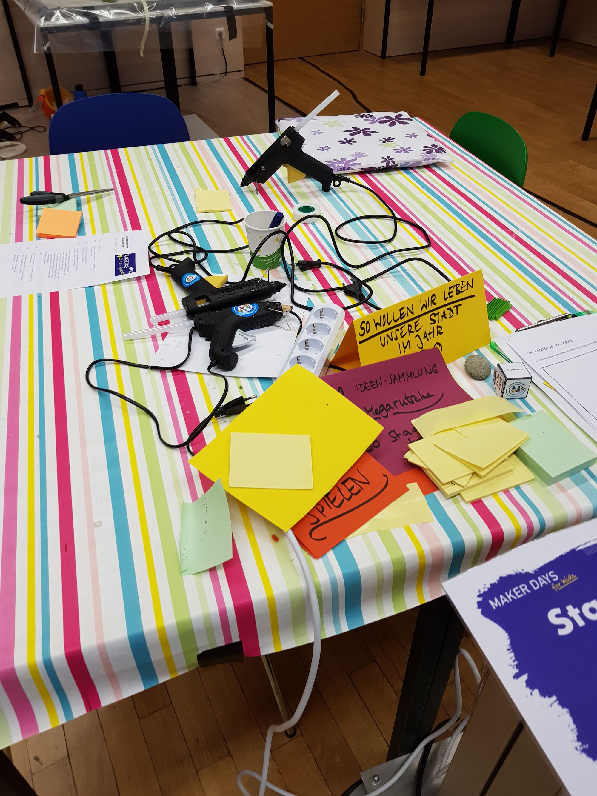 Tisch mit diversen Heissklebepistolen. 