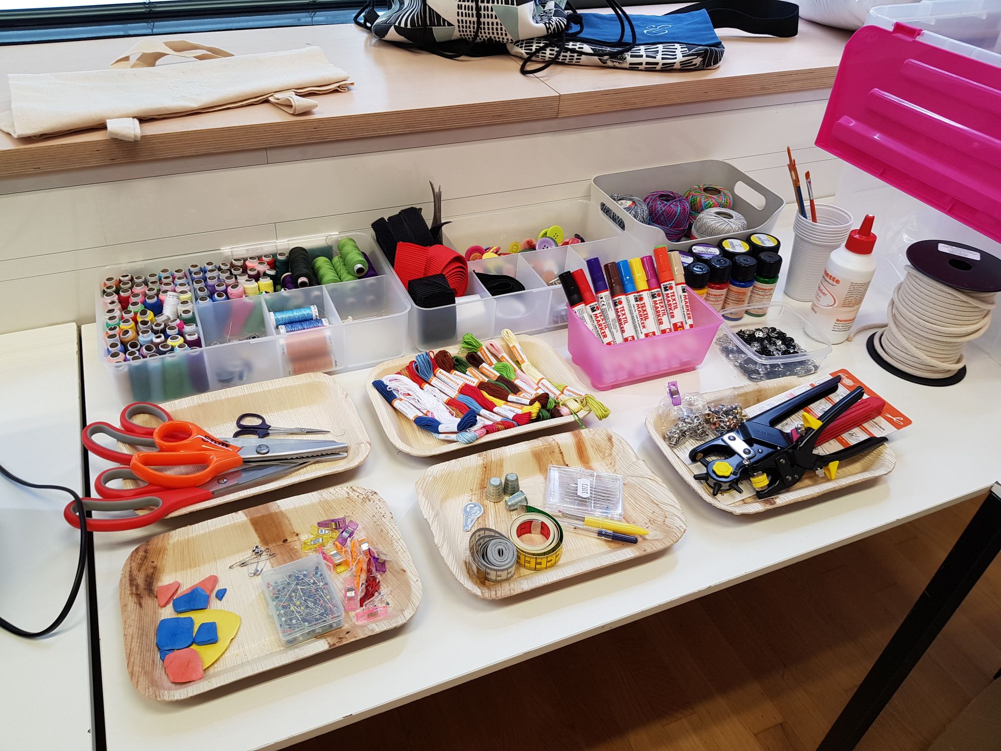 Faden, Scheren, Stifte, Ösenzangen, Schnur und weiteres Zubehör zum Nähen und Sticken. 